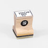 A wooden rubber stamp with a clear top showing the text "you've got snail mail" and a black circle logo with a white "p" on the front.