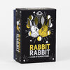 A black rectangular game box with illustrated white and gold rabbit heads and the text "RABBIT RABBIT" and "A GAME OF SUPERSTITIONS" on the front.