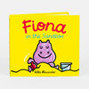 A small yellow hardcover book titled "Fiona in the Sandbox" with a purple hippopotamus illustration and the author name "Rilla Alexander" on the cover.