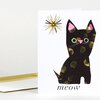 A folded greeting card with a black cat illustration, a small starburst shape near the top left, and the word "meow" printed at the bottom.