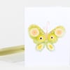 A folded greeting card with a stylized green butterfly illustration on the front and a matching envelope.