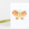 A folded greeting card with a colorful butterfly illustration featuring pink, yellow, green, and orange details on a white front.