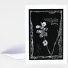 A folded greeting card with a black-and-white floral illustration and the text "something just beneath the surface is preparing to bloom."