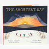 A hardcover book titled "THE SHORTEST DAY" with a illustrated cover showing a sunrise over hills and several small figures playing in snow, with the names Susan Cooper and Carson Ellis printed on the front.
