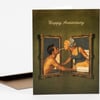 A folded greeting card with the words "Happy Anniversary" printed at the top and an illustration of a man and woman facing each other through ornate framed mirrors.