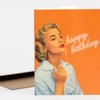 A folded greeting card with an orange cover featuring an illustrated woman holding a cigarette and the words "happy birthday" in white script.