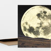 A greeting card with a large moon illustration over a western landscape and the text "Happy Father's Day" curved across the moon.