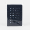 A small black notebook with rounded corners and the word "NOTES" repeated in pale letters with moon-phase symbols replacing one letter in each line.