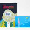 A hardcover book titled "THE LIGHTHOUSE KEEPER" with an illustrated cover showing a bearded figure wearing round glasses, plus a matching postcard-sized image of a lighthouse over blue water and birds.