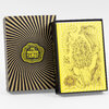 A tarot deck box set with a black-and-yellow striped outer box reading "THE MUSHROOM TAROT" and an inner yellow card stack or booklet showing mushroom and creature illustrations with the text "THE MUSHROOM TAROT" and "BY CHRIS ADAMS".