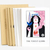 A set of illustrated art cards with a kraft paper envelope and a front card titled "THE FOREST QUEEN" featuring a stylized woman with black hair, pink and blue accents, and floral imagery.