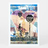 A postcard-style print shows a cyclist on a bicycle in front of a large heart shape, a stop sign that reads "STOP for LOVE," and a small traffic light with the word "WAY" visible on it.