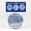 A packaged set of round coasters labeled "Portland, Oregon Marquee Coasters" with three blue-and-white Portland sign designs visible.