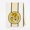 A cream-colored square cloth with vertical yellow and black stripes and a small floral-and-bee illustration near the top and bottom center.