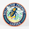 A circular sign with an orange border and navy center reads "POLLINATOR FRIENDLY GARDEN" around a large illustrated bee over flowers and leaves.