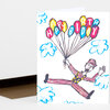 A folded birthday card with a colorful illustration of a clown holding balloon letters that spell "HAPPY BIRTHDAY."