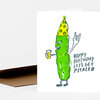 A folded birthday card shows a cartoon pickle wearing a party hat, holding a drink and making a rock hand sign, with the text "HAPPY BIRTHDAY LET'S GET PICKLED".