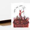 A folded birthday card with a red and black illustration of a horned figure standing above flames and the text "HOPE YOU HAVE ONE HELL OF A BIRTHDAY" on the front.
