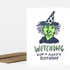 A folded birthday card with a green witch illustration and the text "WITCHING YOU A HAPPY BIRTHDAY" on the front.