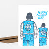 A folded greeting card showing two illustrated figures from behind in blue denim outfits with patches reading "RAD DAD" and "RAD KID," and the text "HAPPY FATHER'S DAY."