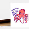 A folded greeting card with an illustration of a red-orange octopus and purple text reading “LOVE YOU WITH ALL MY HEARTS.”