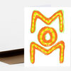 A folded greeting card with a hand-drawn stylized orange and yellow letter M and a circular O on the front.
