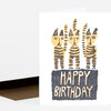 A folded birthday card with three illustrated striped cats above the words "HAPPY BIRTHDAY".