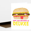 A folded greeting card shows a cartoon hamburger with eyes and a red tongue above the text "HOPE YOUR BIRTHDAY IS DELUXE."