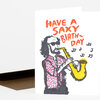 A folded birthday card with a hand-drawn saxophone player and the text "HAVE A SAXY BIRTH-DAY" on the front.