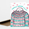 A folded holiday greeting card with the text "WARMEST HOLIDAY WISHES" and a hand-drawn illustration of a bundled person in a patterned sweater with red and teal snowflake motifs.