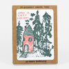 A kraft cardboard box set of six letterpress printed holiday cards with kraft envelopes, showing a card with a pink house and dark green trees and the text "HAVE A COZY HOLIDAY" and "SIX LETTERPRESS PRINTED CARDS".