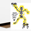 A folded greeting card shows a black-and-yellow illustrated skeleton with the handwritten text "THANKS FOR FIXIN' STUFF DAD!" and a small heart.