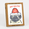 A boxed set labeled "BAH HUM PUG" with a illustrated pug wearing a Santa hat on the front and the text "SIX LETTERPRESS PRINTED CARDS" and "W/ KRAFT ENVELOPES."