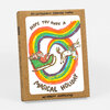 A kraft paper box set labeled "SIX LETTERPRESS PRINTED CARDS" and "w/ KRAFT ENVELOPES," with a front illustration of Santa in a sleigh and a unicorn surrounded by rainbow swirls and the text "HOPE YOU HAVE A MAGICAL HOLIDAY."