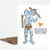 A folded greeting card shows a two-headed blue-gray illustrated figure with orange clubs and the text "WE MAKE A GRUESOME TWOSOME" on the front.