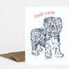 A folded greeting card with a black-and-white illustrated dog and the pink text "YOU'RE CUTE" on the front.