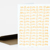 A folded greeting card with a white front covered in a grid of hand-painted orange "mom" text.