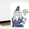 A folded greeting card with a hand-drawn wizard in a purple robe and pointed hat covered in yellow stars, with the text "HAVE A MAGICAL BIRTHDAY" on the front.