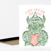 A folded greeting card with a green one-eyed monster holding a pink heart and the handwritten text "I ONLY HAVE EYE FOR YOU" on the front.