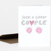 A folded greeting card with the text "SUCH A GREAT COUPLE" and two pink smiling face illustrations separated by a pink heart.