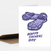 A folded greeting card with two purple illustrated crocs and the text "HAPPY FATHER'S DAY" on the front.