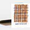 A folded greeting card with an orange and navy plaid design and the text "HAPPY FATHER'S DAY" on the front.