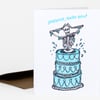 Folded greeting card with a blue tiered cake illustration topped by a skeleton and the text "SURPRISE, YOU'RE OLD!"