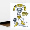 A folded greeting card shows a hand-drawn wrestler lifting a championship belt, with the text "HAPPY BIRTHDAY CHAMP" printed beside the figure.