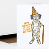 A folded birthday card featuring a hand-drawn dog wearing a party hat and holding a cane, with orange text that reads "HAPPY BIRTHDAY AT LEAST IT'S NOT DOG YEARS."