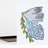 A greeting card featuring a gray dove carrying a green olive branch with the word "PEACE" in large blue letters.