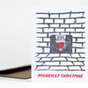 A white holiday greeting card with a sketchy black brick fireplace and a red-and-white Santa figure in the opening, with the text "MERRIEST CHRISTMAS" printed at the bottom.