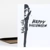 A black-and-white greeting card featuring a partial vampire illustration and the text "HAPPY HALLOWEEN" in bold brush lettering.